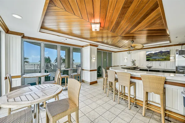 a dining hall with stainless steel appliances kitchen island granite countertop a table and chairs