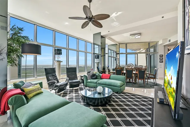 a living room with patio furniture and a chandelier