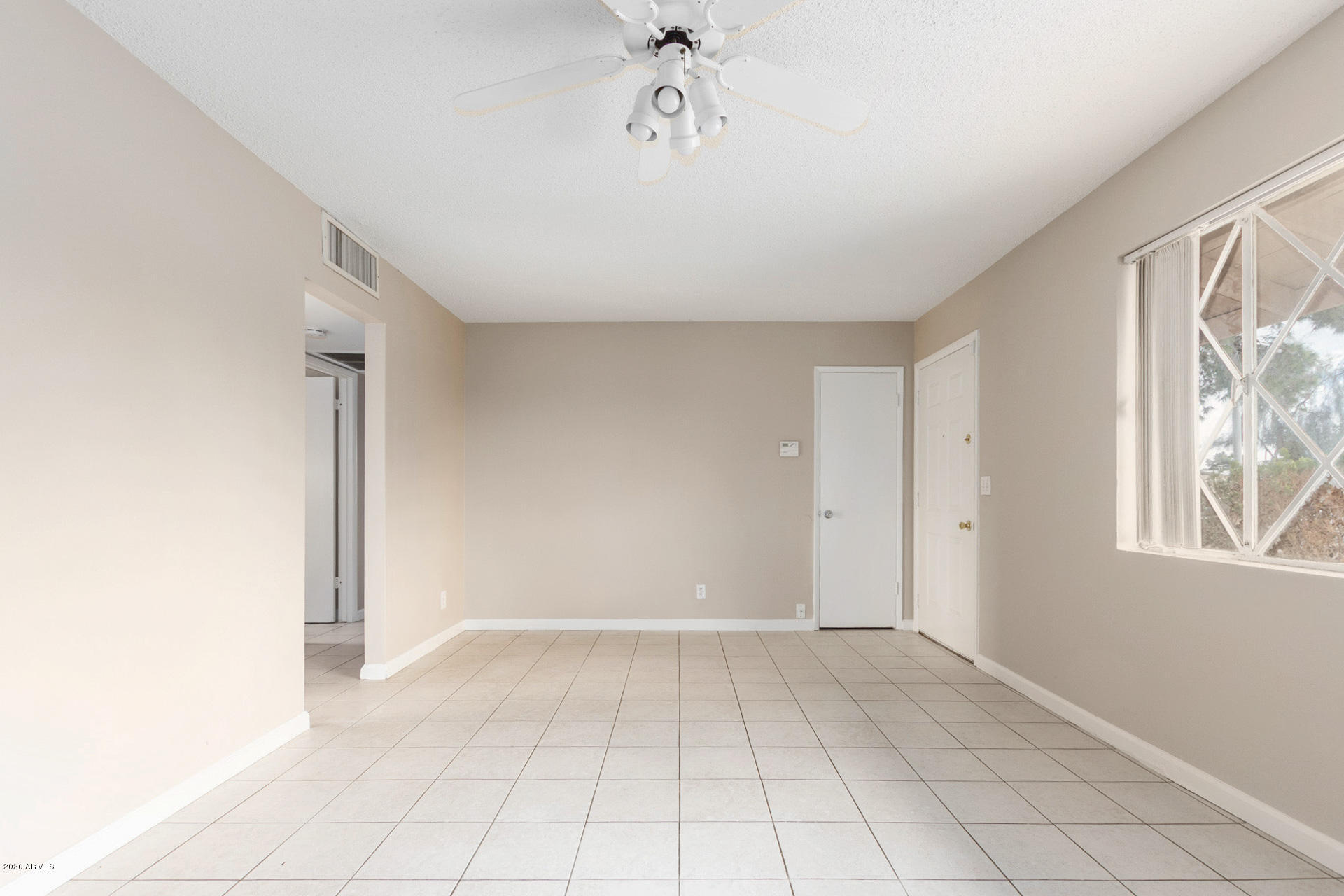 3320 West Cactus Road Phoenix, AZ 85029 - Photo 5 of 29 a view of an empty room with window and chandelier fan