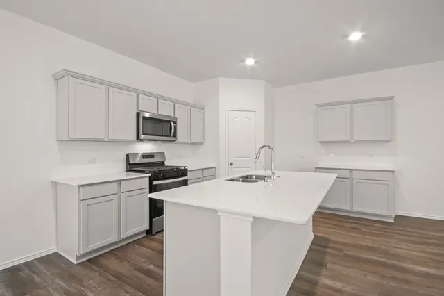 a kitchen with a sink a stove and cabinets