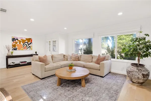 a living room with furniture a rug and a dining table