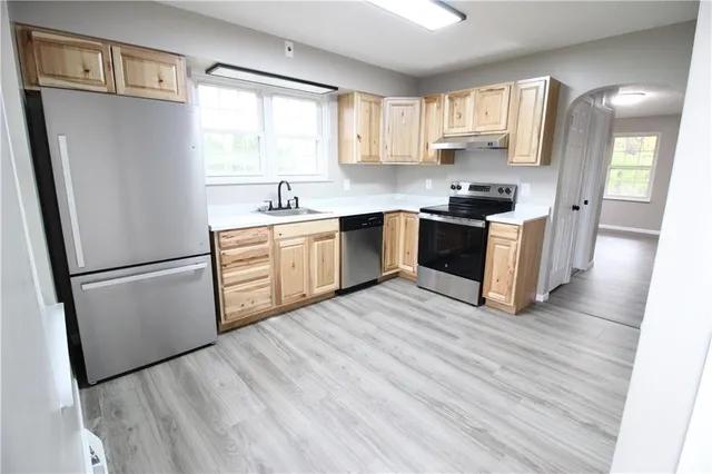a kitchen with stainless steel appliances a refrigerator sink and microwave