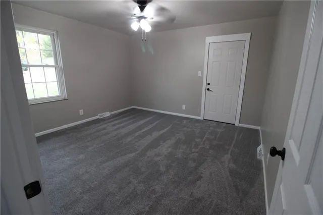 en empty room with windows and fan