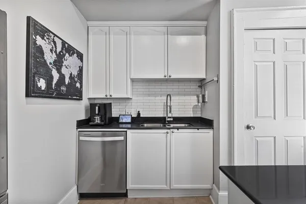 a kitchen with stainless steel appliances granite countertop a stove a sink and white cabinets