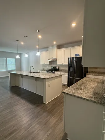 a large kitchen with stainless steel appliances kitchen island a cabinets and wooden floor