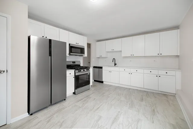 a kitchen with stainless steel appliances a refrigerator sink and cabinets