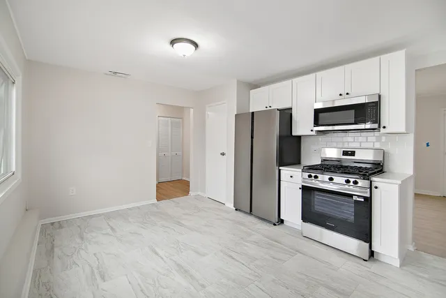 a kitchen with stainless steel appliances a stove a microwave and a refrigerator