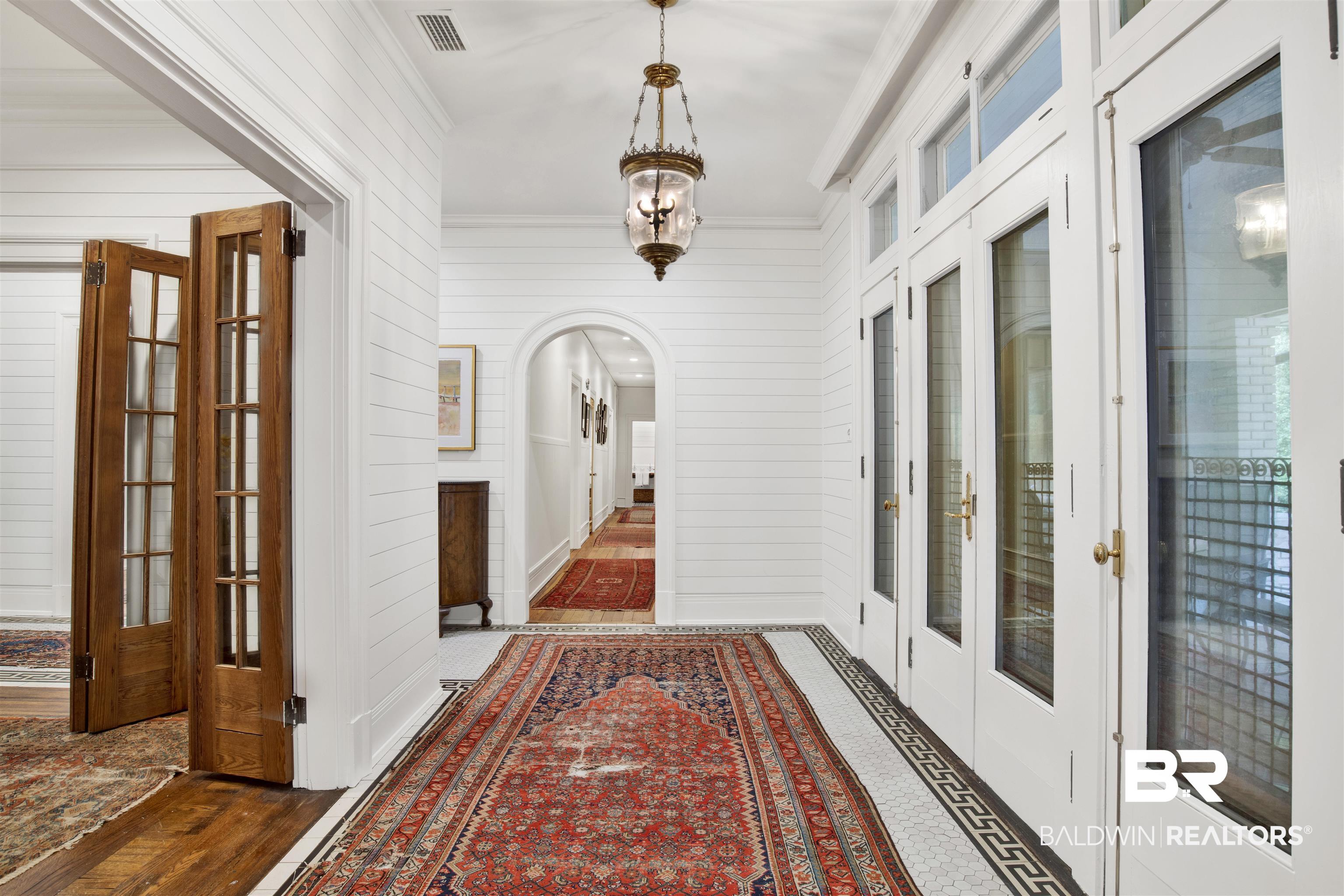 1654 Government Street Mobile, AL 36604 - Photo 17 of 45 Hallway with dark wood-type flooring, french doors, and ornamental molding