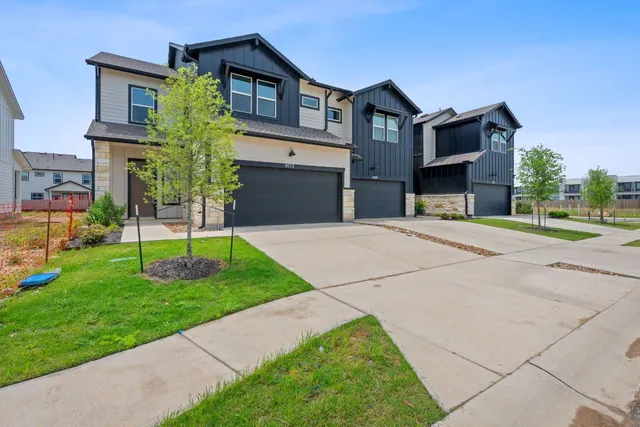 a front view of a house with a yard and trees
