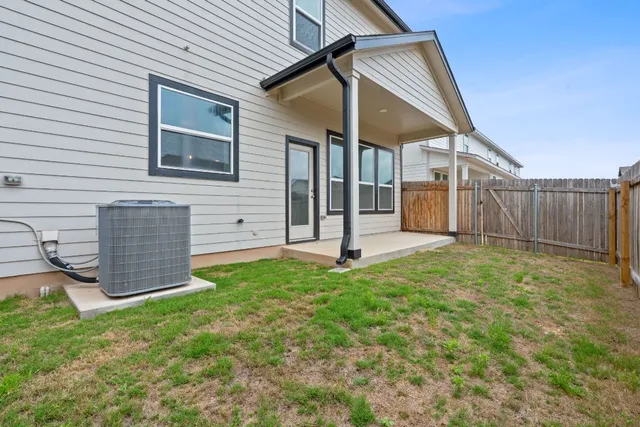 a view of a house with a yard and wooden fence