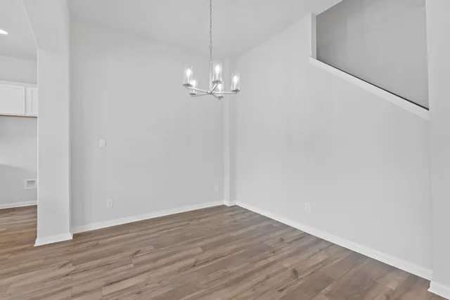 a view of a chandelier in big room with wooden floor