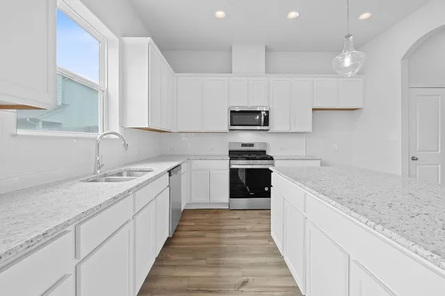 a kitchen with stainless steel appliances granite countertop a sink stove and refrigerator