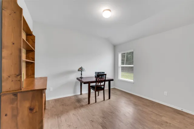 a view of a workspace with furniture and a window