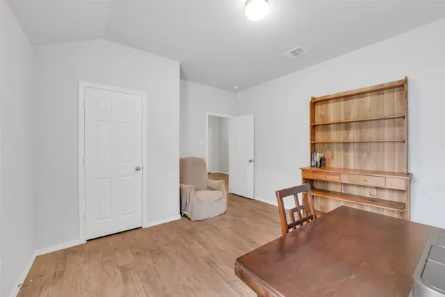 a workspace room with wooden floor and windows