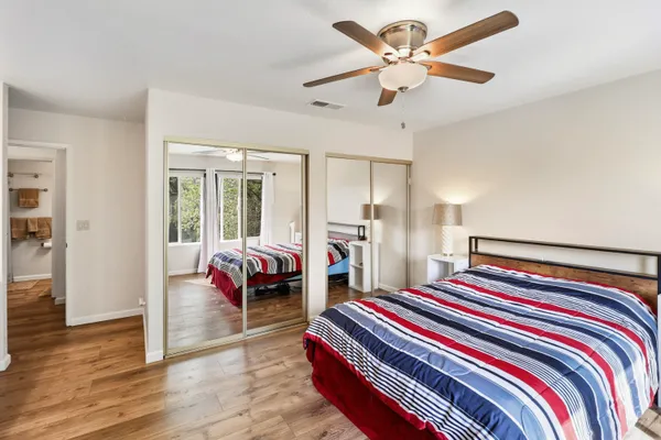 a bedroom with a bed and a chandelier fan