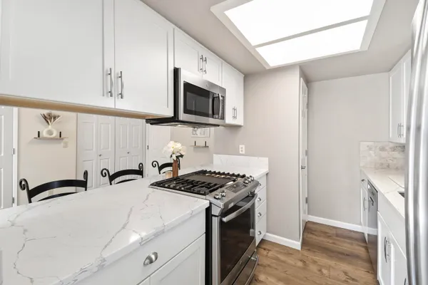 a kitchen with stainless steel appliances granite countertop a sink and a stove