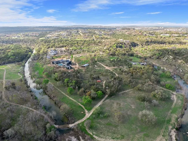 an aerial view of residential houses with outdoor space and trees