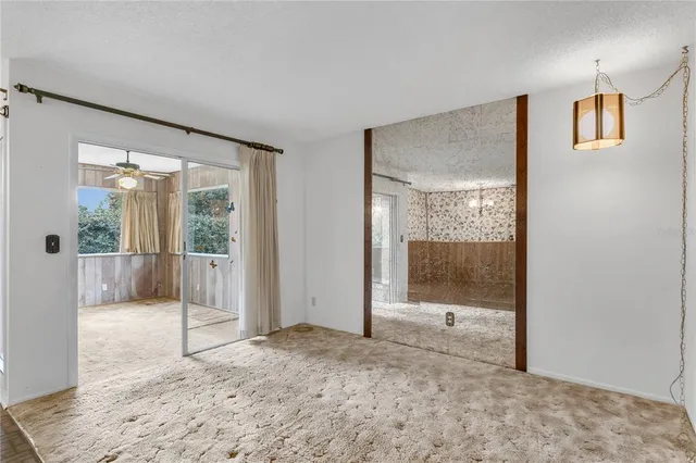 a view of an empty room with wooden floor and entryway