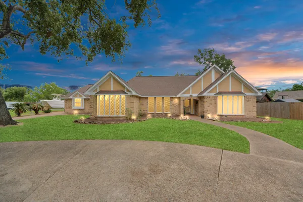 a view of a house next to a yard and wooden fence