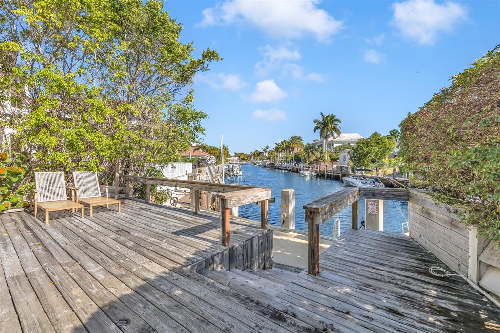 2801 Northeast 48th Court Lighthouse Point, FL 33064 - Photo 23 of 50 a view of a roof deck with table and chairs with wooden floor and fence