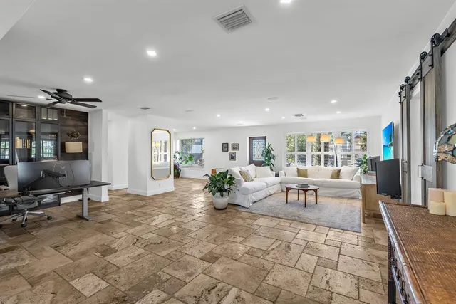 a kitchen with stainless steel appliances granite countertop a stove a refrigerator a dining table and chairs with wooden floor