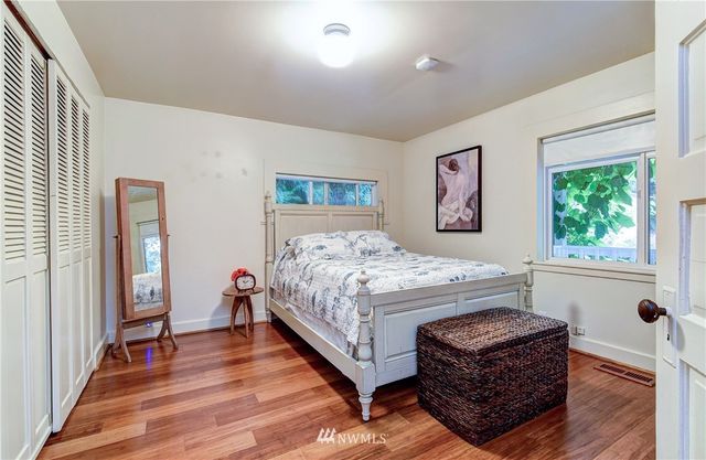 a bedroom with a bed wooden floor and window