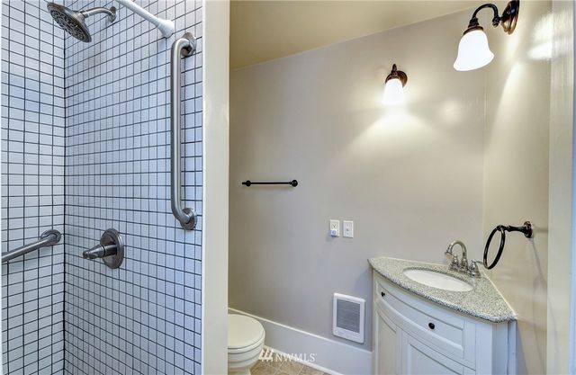 a bathroom with a granite countertop toilet sink and mirror