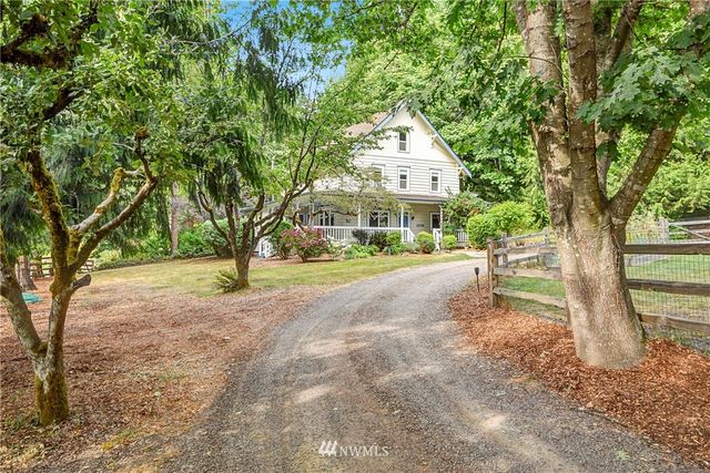 a view of a house with large trees and a small yard