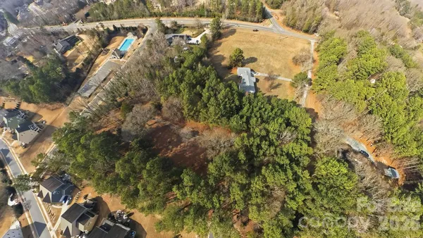 an aerial view of residential houses with outdoor space and trees