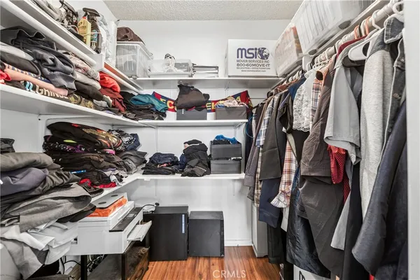 a view of walk in closet with clothes and shoes