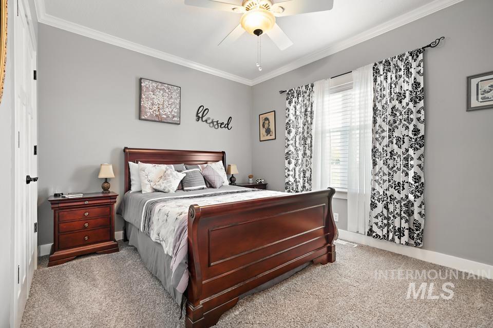 8271 Washoe Road Fruitland, ID 83619 - Photo 26 of 29 Carpeted room with a ceiling fan light fixture, crown molding, and a window featuring blinds and dark patterned curtains