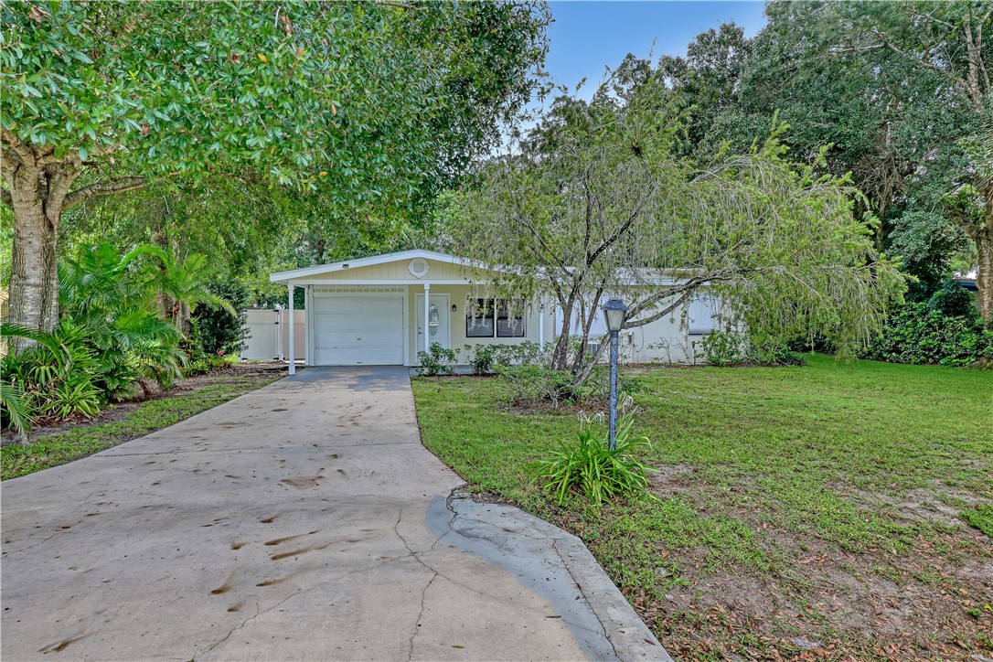 a front view of a house with a yard and trees