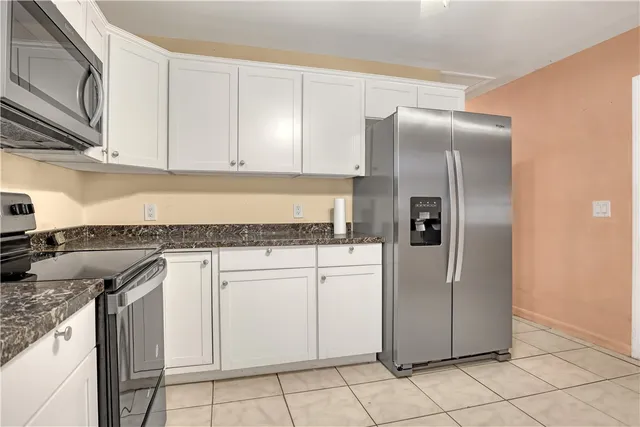a kitchen with stainless steel appliances granite countertop a refrigerator a stove and a sink