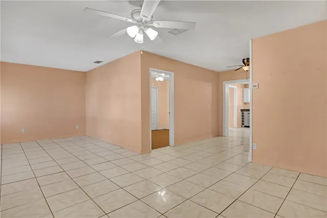 an empty room with fan and entryway