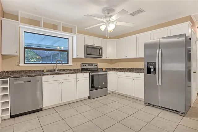 a kitchen with white cabinets and stainless steel appliances