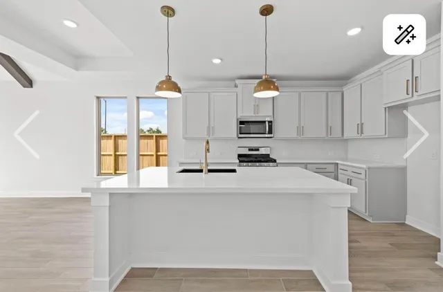 a kitchen with kitchen island a counter top space a sink stainless steel appliances and cabinets