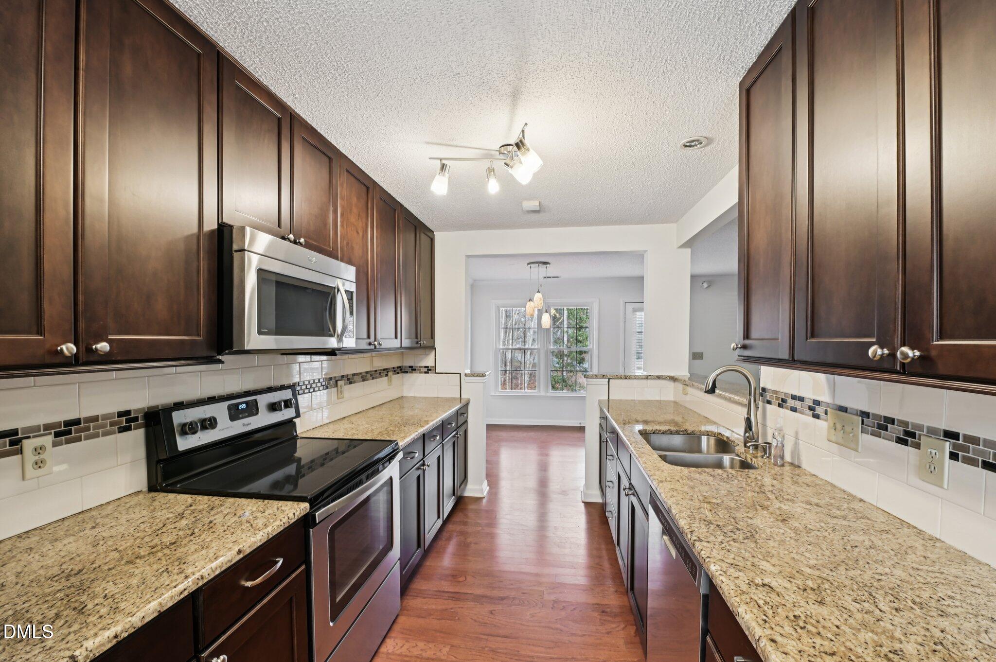 135 Long Shadow Place Durham, NC 27713 - Photo 11 of 23 an open kitchen with granite countertop stainless steel appliances and wooden cabinets