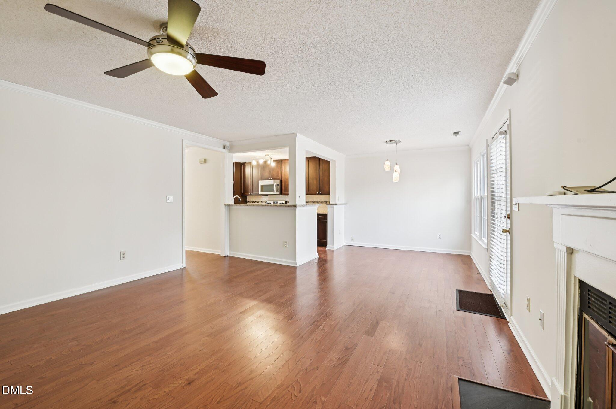 135 Long Shadow Place Durham, NC 27713 - Photo 6 of 23 a view of a kitchen with a sink a ceiling fan and wooden floor
