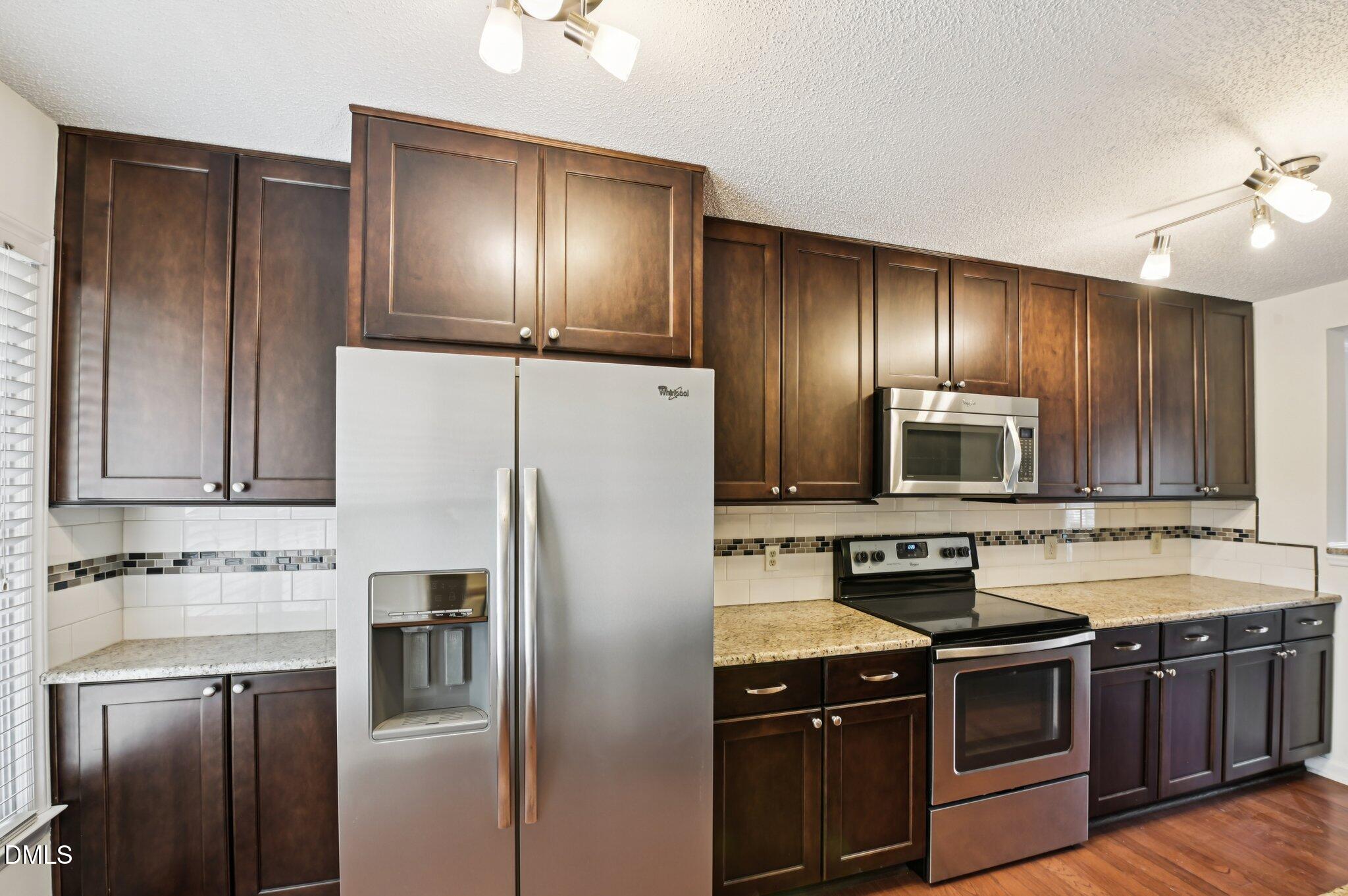 135 Long Shadow Place Durham, NC 27713 - Photo 10 of 23 a kitchen with stainless steel appliances wooden cabinets and a stove