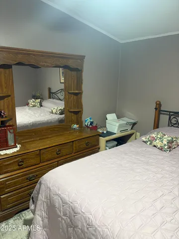 a bedroom with a bed and a painting on the wall