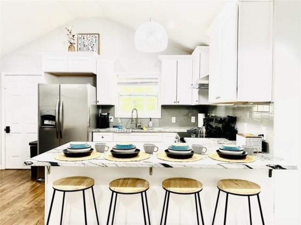 85 Meldon Avenue Southeast Atlanta, GA 30315 - Photo 5 of 23 a kitchen with a table chairs and a stove top oven with white cabinets