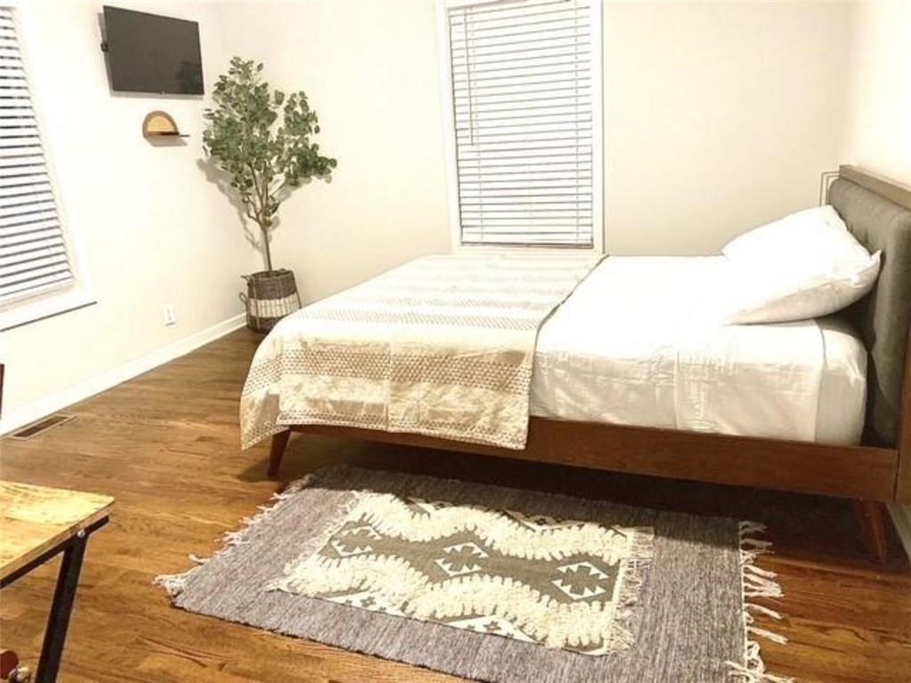 85 Meldon Avenue Southeast Atlanta, GA 30315 - Photo 10 of 23 a bed sitting in a bedroom next to a window with potted plants