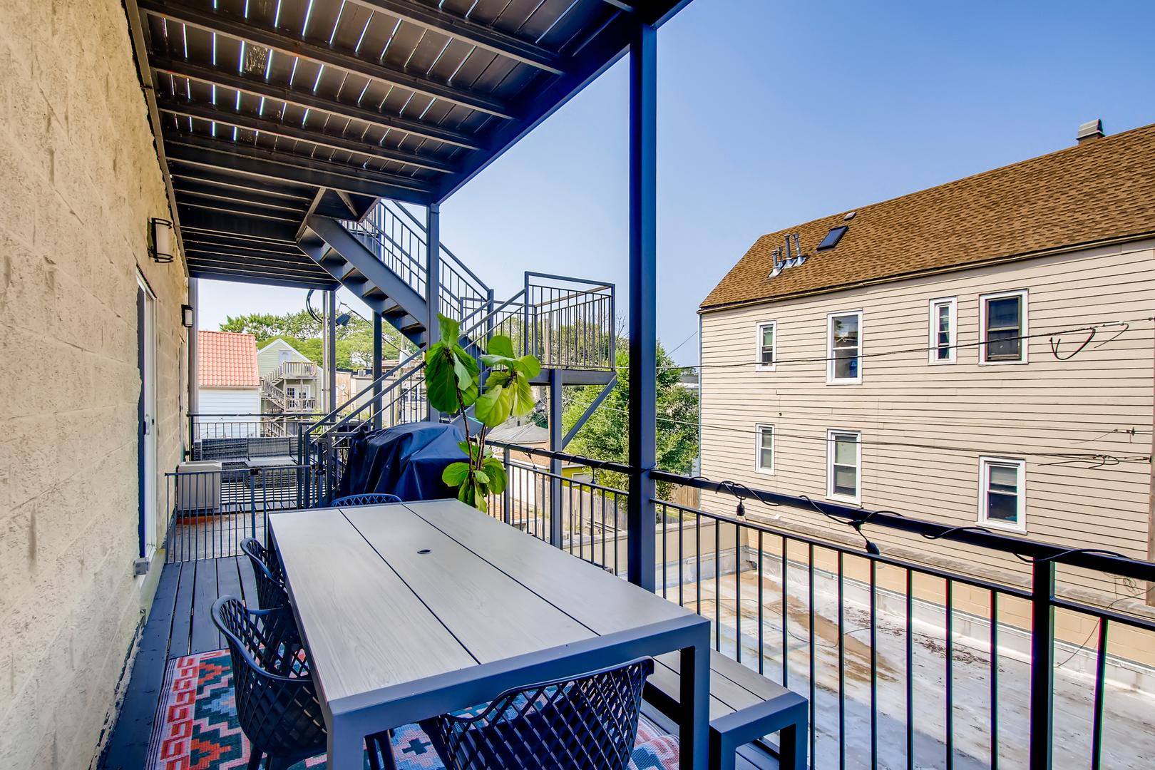 3744 West George Street, Unit D Chicago, IL 60618 - Photo 27 of 30 a view of a patio with table and chairs with wooden floor and fence