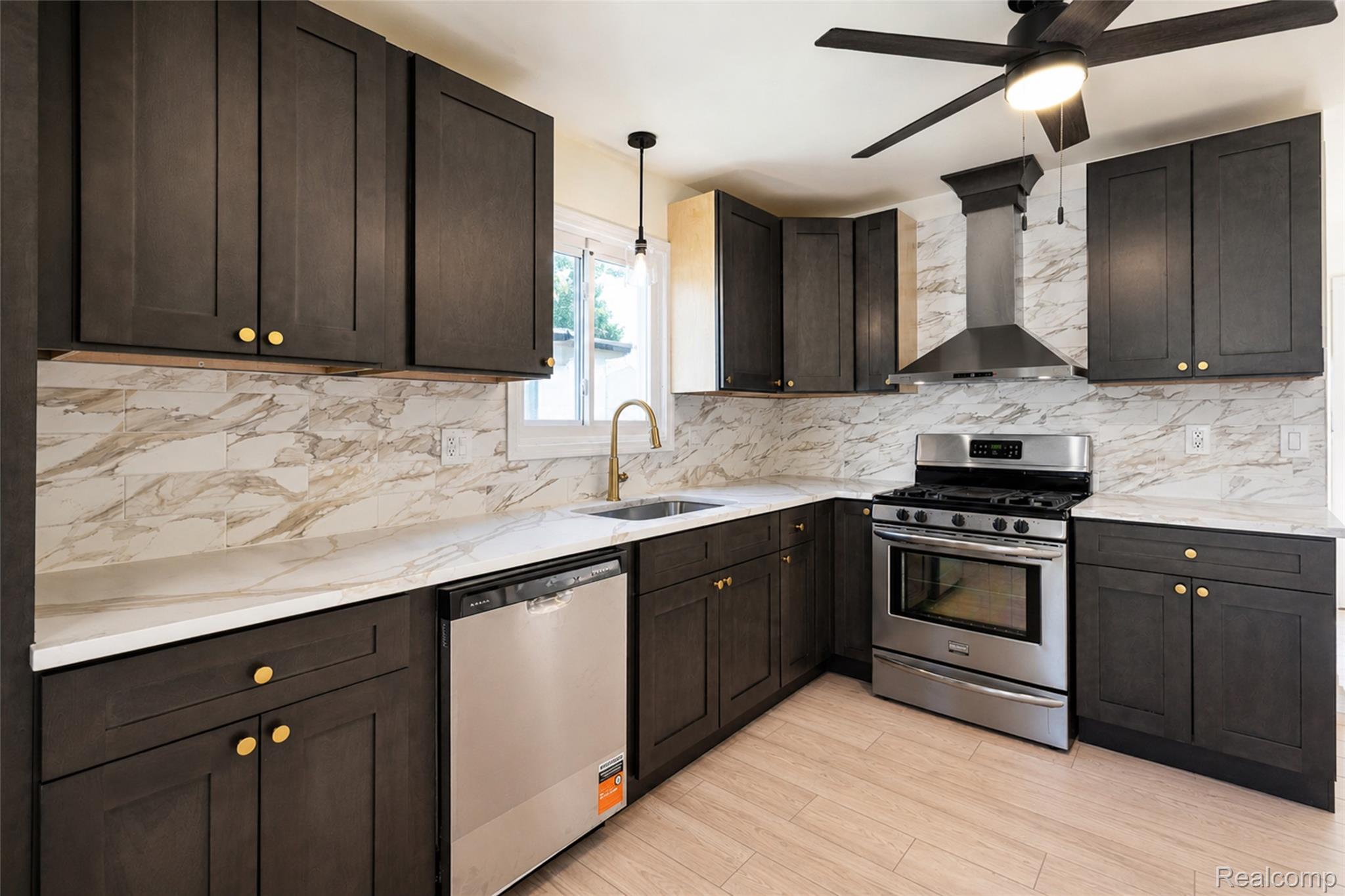 201 Cardwell Street Inkster, MI 48141 - Photo 14 of 41 Contemporary kitchen featuring dark wood-finish cabinetry with gold-tone hardware, white countertops, and a full tile backsplash