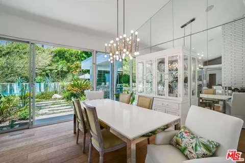 a view of a dining room with furniture a chandelier and wooden floor
