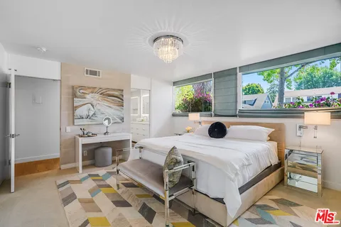 a bedroom with furniture and a large window
