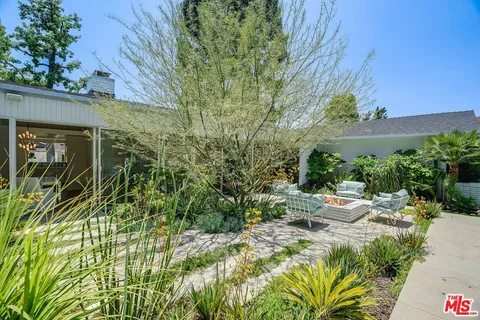 a backyard of a house with table and chairs