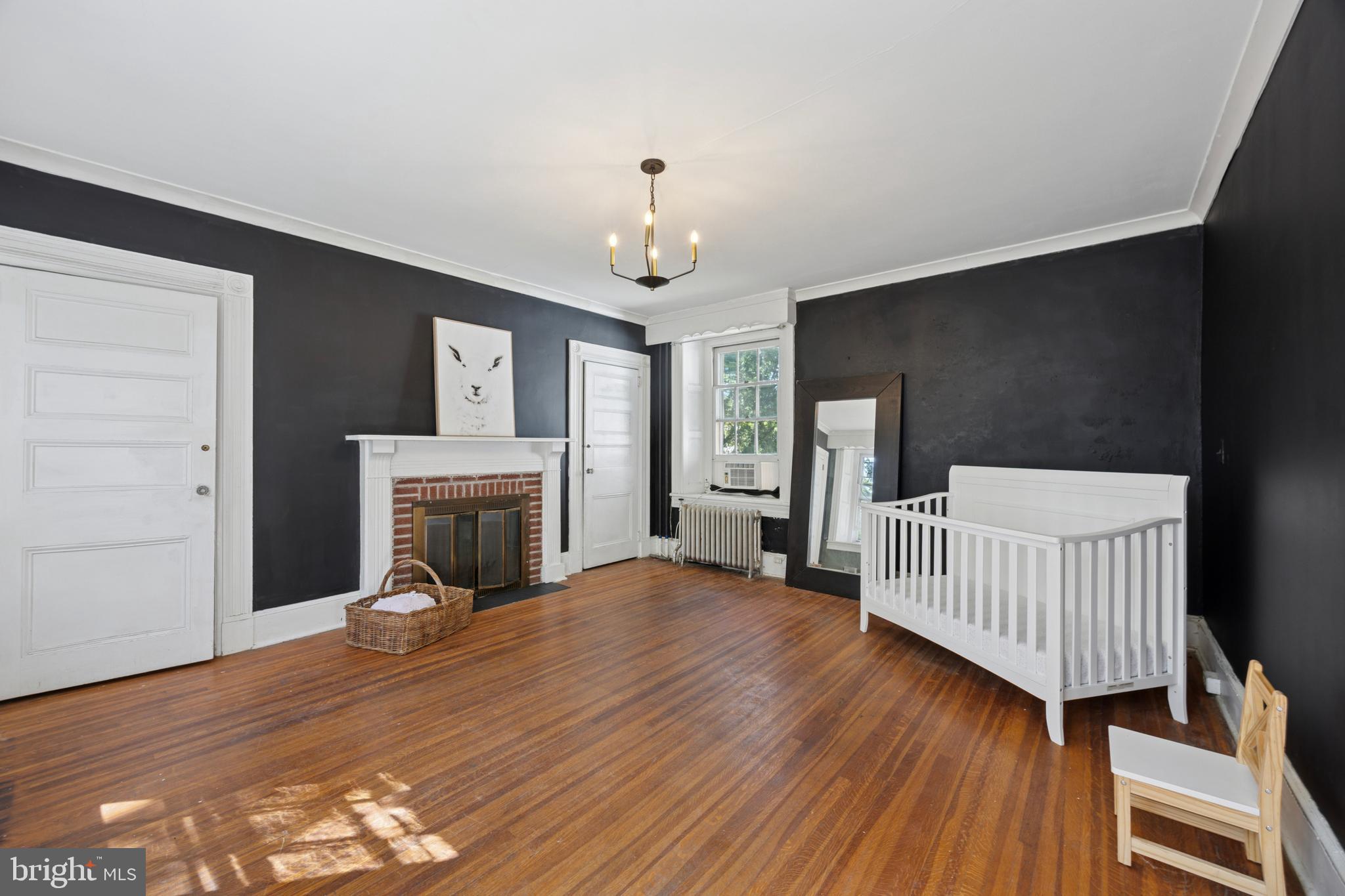 212 West 24th Street Chester, PA 19013 - Photo 17 of 30 a view of a livingroom with a fireplace a chandelier and wooden floor