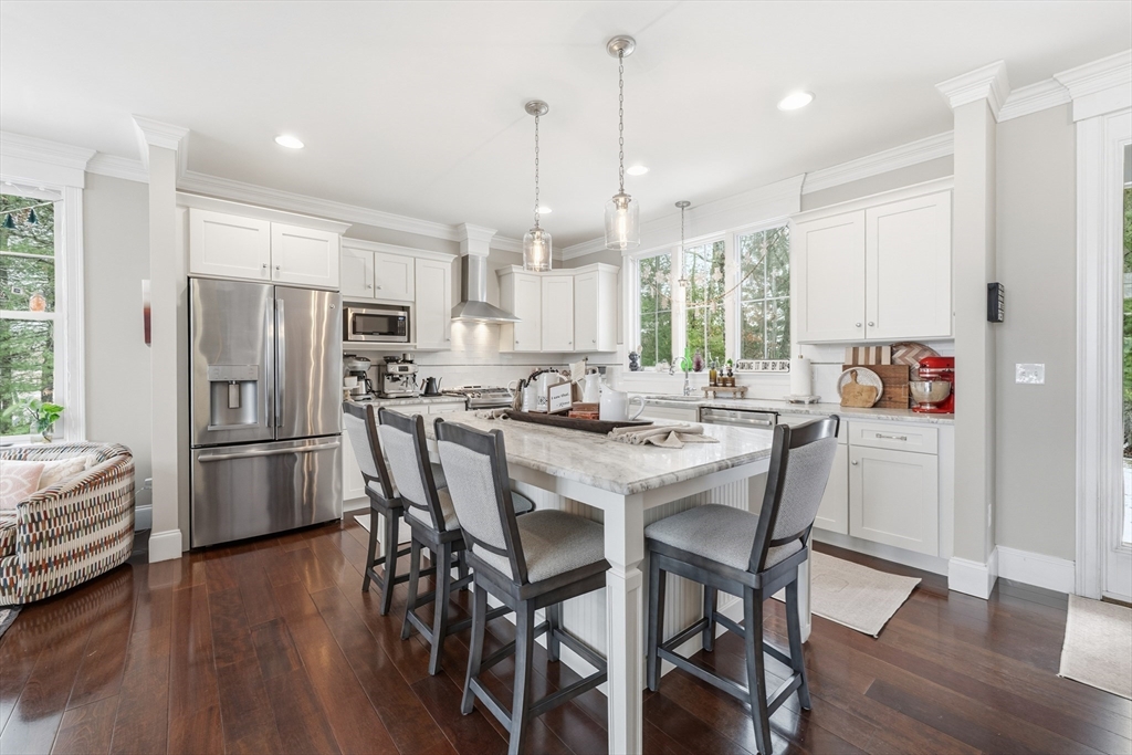 187 Rhode Island Road Lakeville, MA 02347 - Photo 6 of 42 a kitchen with stainless steel appliances a dining table chairs refrigerator sink and cabinets