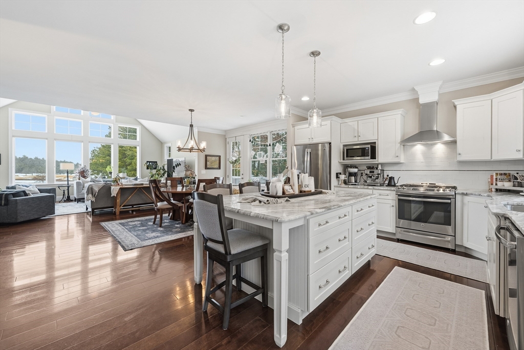 187 Rhode Island Road Lakeville, MA 02347 - Photo 8 of 42 a kitchen with stainless steel appliances granite countertop a stove a refrigerator a kitchen island furniture and a fireplace